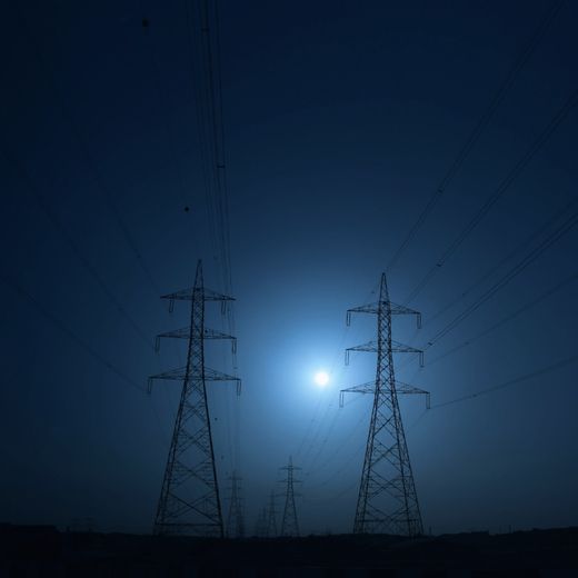 Pylônes d'une ligne à haute tension dans un halo de lumière