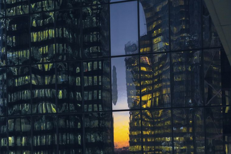 Tours de bureaux se reflétant dans une façade de verre à la tombée du jour