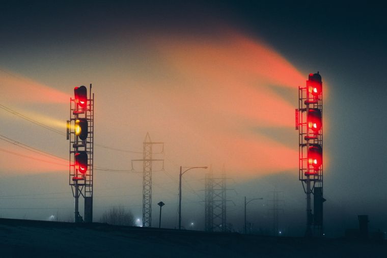 Signaux ferroviaires allumés dans la brume, de nuit