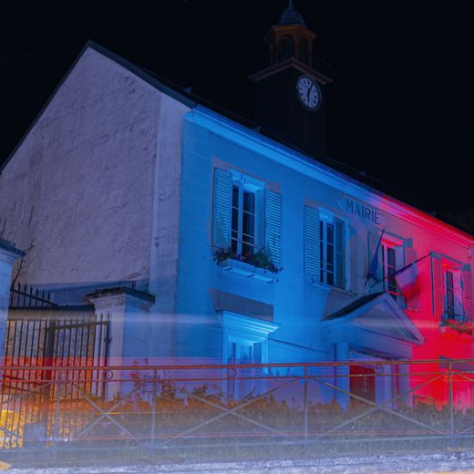 Mairie illuminée aux couleurs bleu, blanc, rouge
